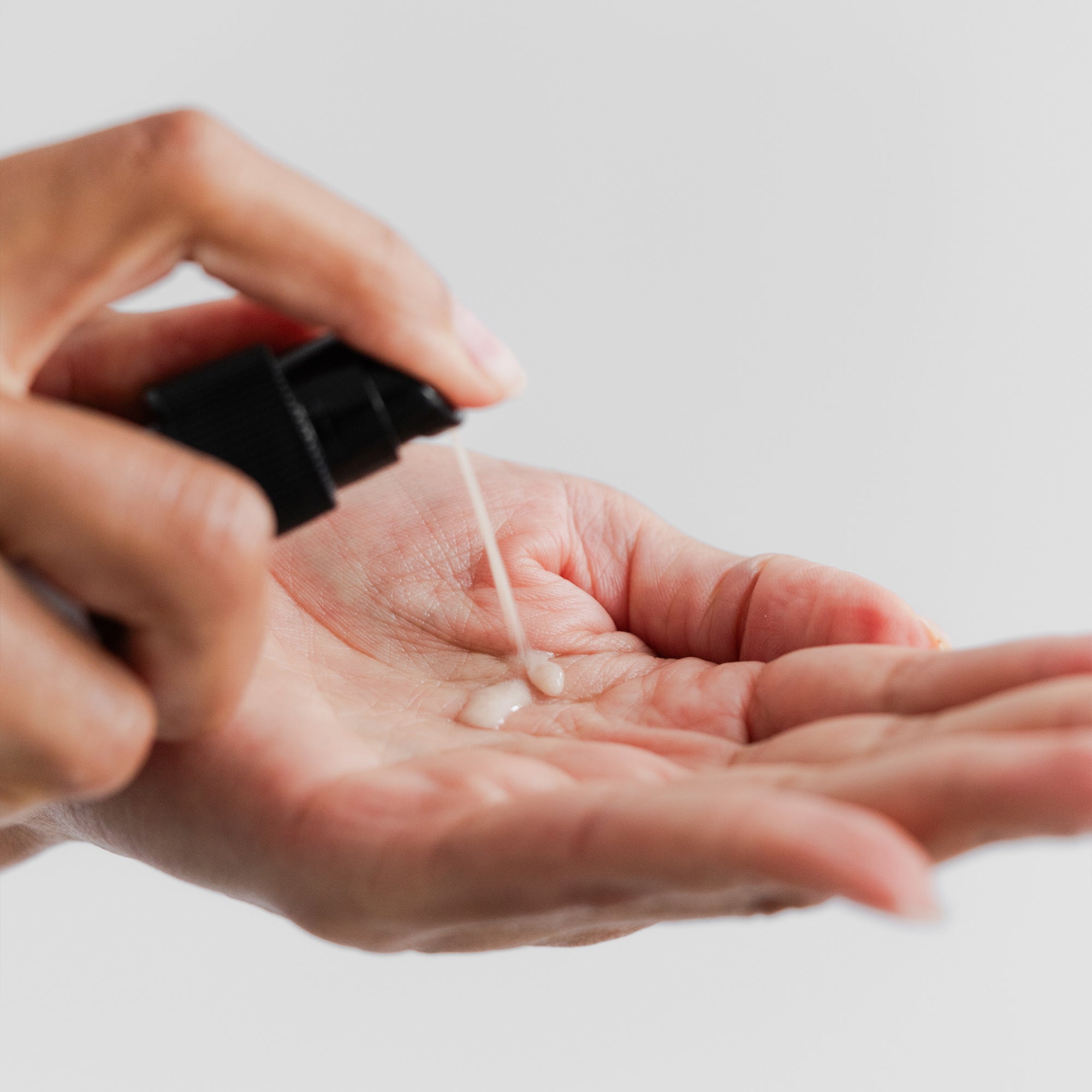 Hand using pump to spray product into hand to see texture of Marie Veronique Intensive Repair Serum 1 oz / 30 ml. HAs+B5+B3 are powerful compounds for chron- ic breakouts. Decrease pore size for a smooth complexion. Microbiome-friendly / Fragrance+Essential Oil free